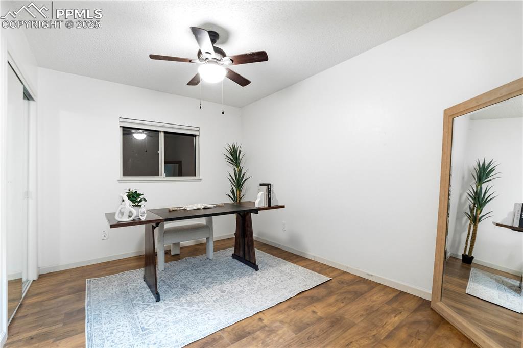 Image 16 of 31: Unfurnished office with wood finished floors, a ceiling fan, and a textured