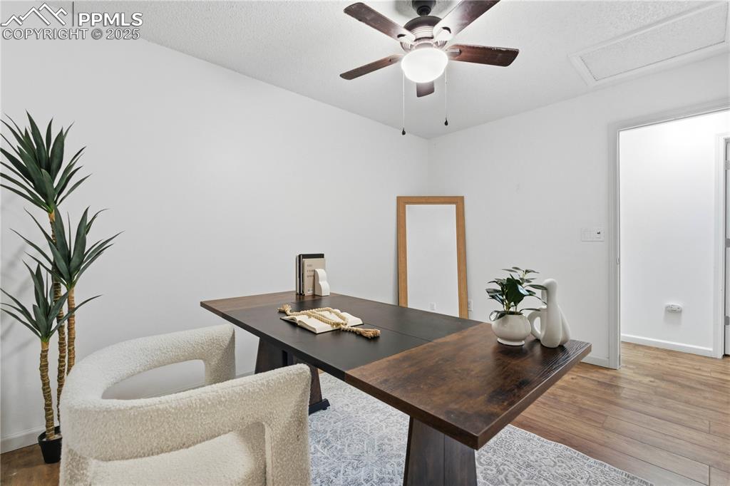Image 17 of 31: Office area with wood finished floors, ceiling fan, and attic access