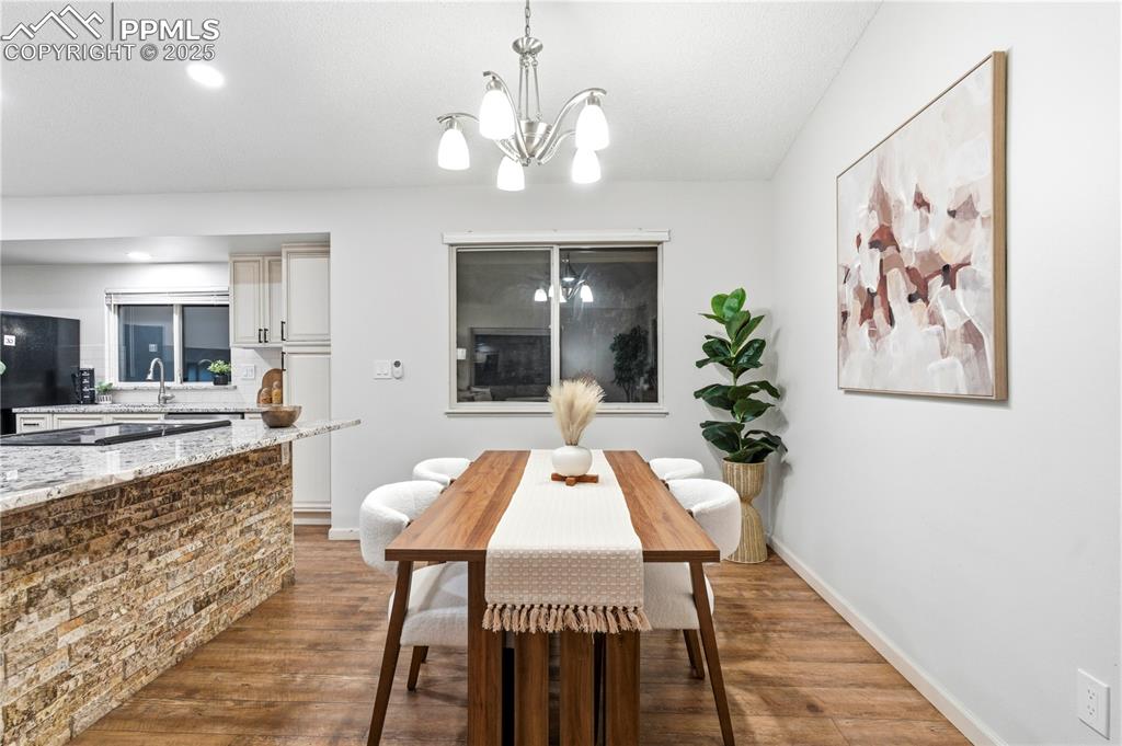 Image 3 of 31: Dining room with light wood-style floors, a chandelier, and recessed lighti