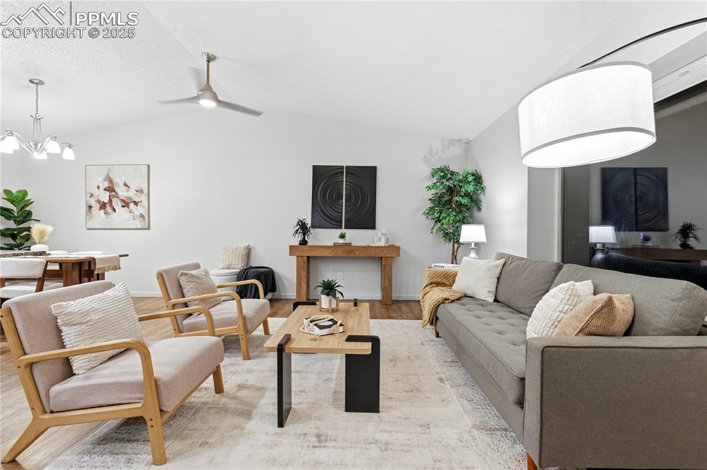 Image 4 of 31: Living room featuring lofted ceiling, wood finished floors, ceiling fan, an