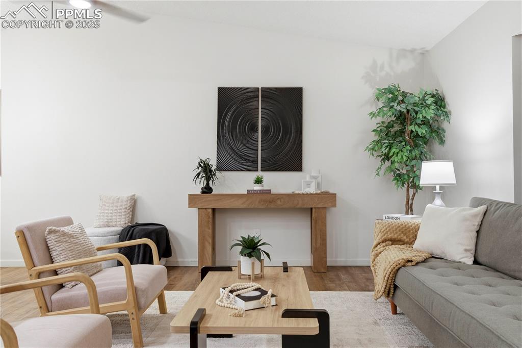 Image 6 of 31: Living room with wood finished floors and vaulted ceiling