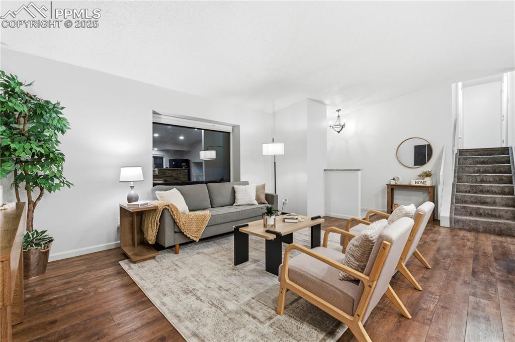 Image 7 of 31: Living room with stairs and dark wood-style flooring