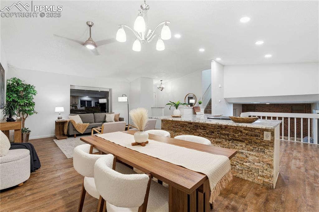 Image 8 of 31: Dining space featuring dark wood-type flooring, recessed lighting, stairway