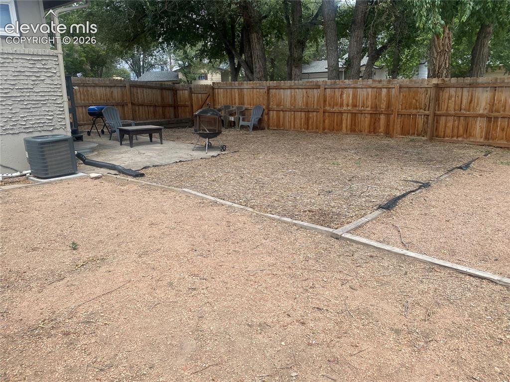Image 26 of 30: Fenced backyard from far rear corner.