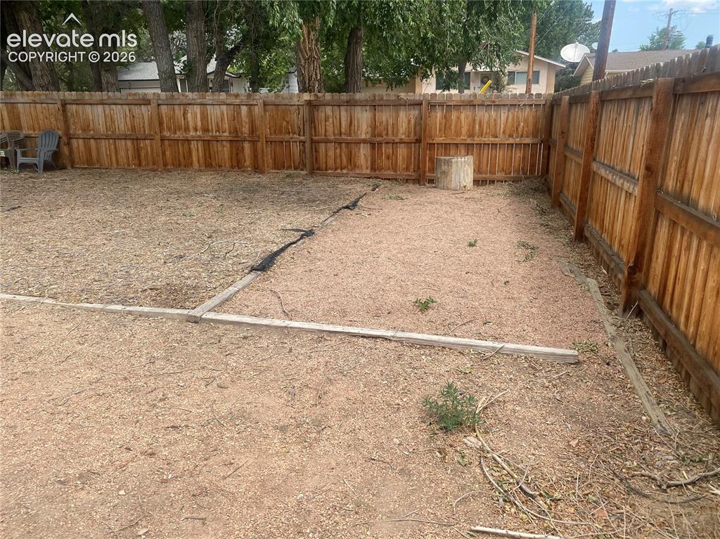 Image 27 of 30: Fenced backyard from rear corner.