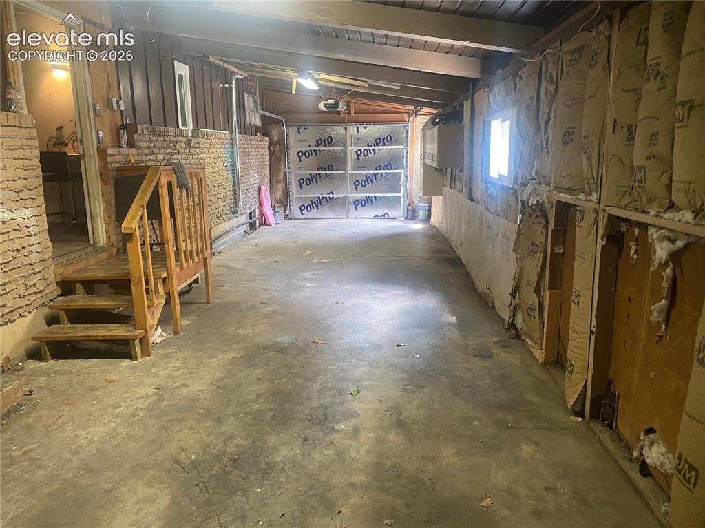 Image 29 of 30: Two-car tandem drive-through garage looking toward front door. 12