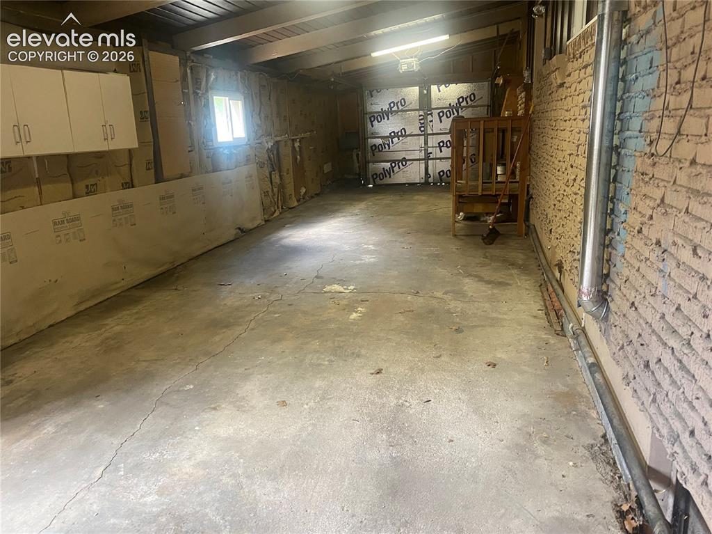 Image 30 of 30: Two-car tandem drive-through garage, from front door looking towards back d