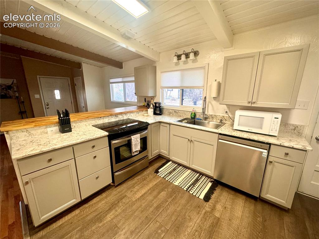 Image 7 of 30: Kitchen area looking towards the main entrance and dining area.