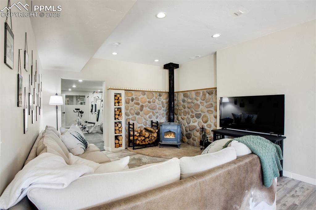 Image 27 of 50: Lower level living room with wood burning fireplace