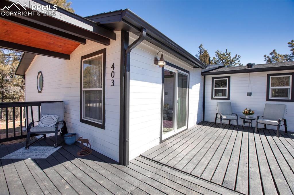 Image 36 of 50: Large wraparound deck with multiple seating areas