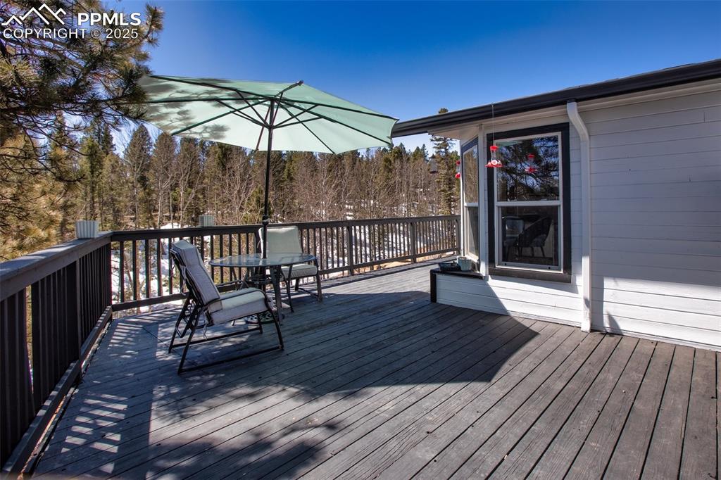 Image 37 of 50: Large wraparound deck with multiple seating areas
