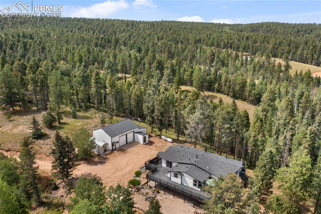 Image 46 of 50: Aerial view of property and surrounding area with a heavily wooded area