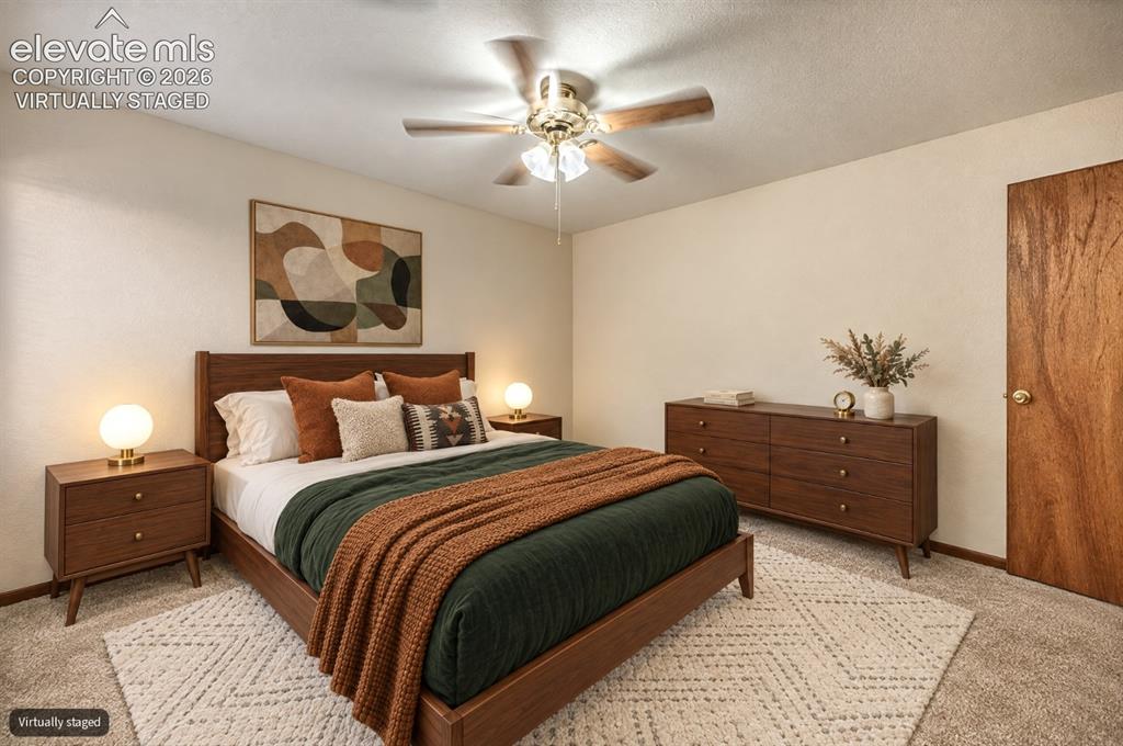 Image 17 of 23: Textured neutral wall paint, ceiling fan with light fixture, wood-finish do