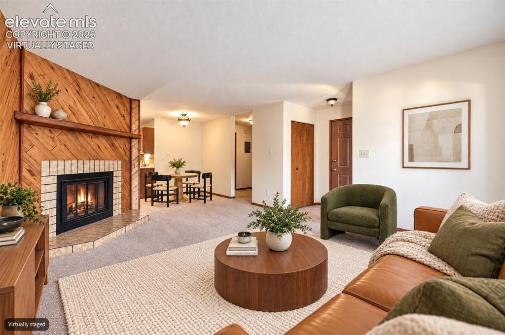 Image 4 of 23: Virtually Staged Wood-paneled accent wall with a brick-surround fireplace