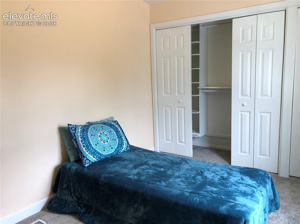 Image 13 of 25: Second Bedroom, Closet space with built in shelving