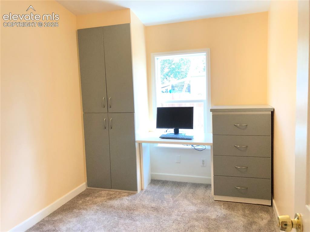 Image 16 of 25: Third bedroom / home office. Built-In Drawers, natural light window.