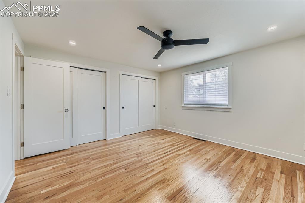 Image 15 of 28: Unfurnished bedroom featuring multiple closets, light wood finished floors,