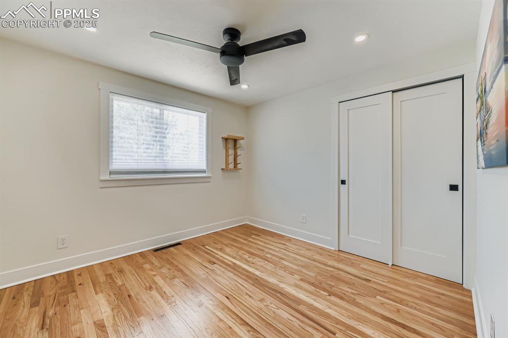 Image 16 of 28: Unfurnished bedroom featuring light wood finished floors, ceiling fan, a cl