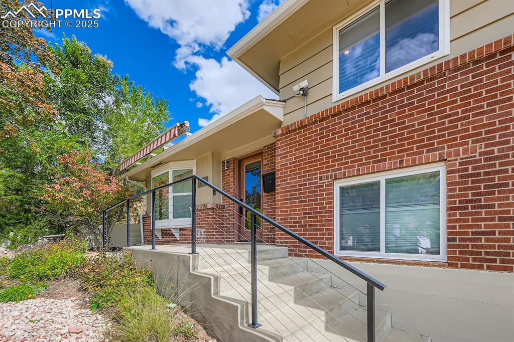 Image 2 of 28: Doorway to property with brick siding
