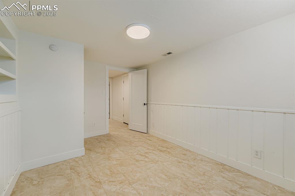 Image 20 of 28: Empty room featuring baseboards and wainscoting
