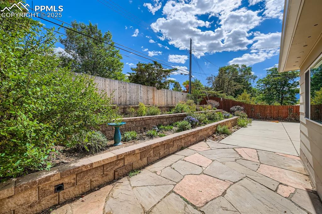 Image 25 of 28: Fenced backyard featuring a patio