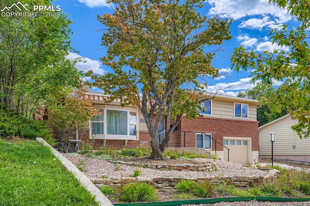 Image 27 of 28: View of front of property featuring brick siding and a garage
