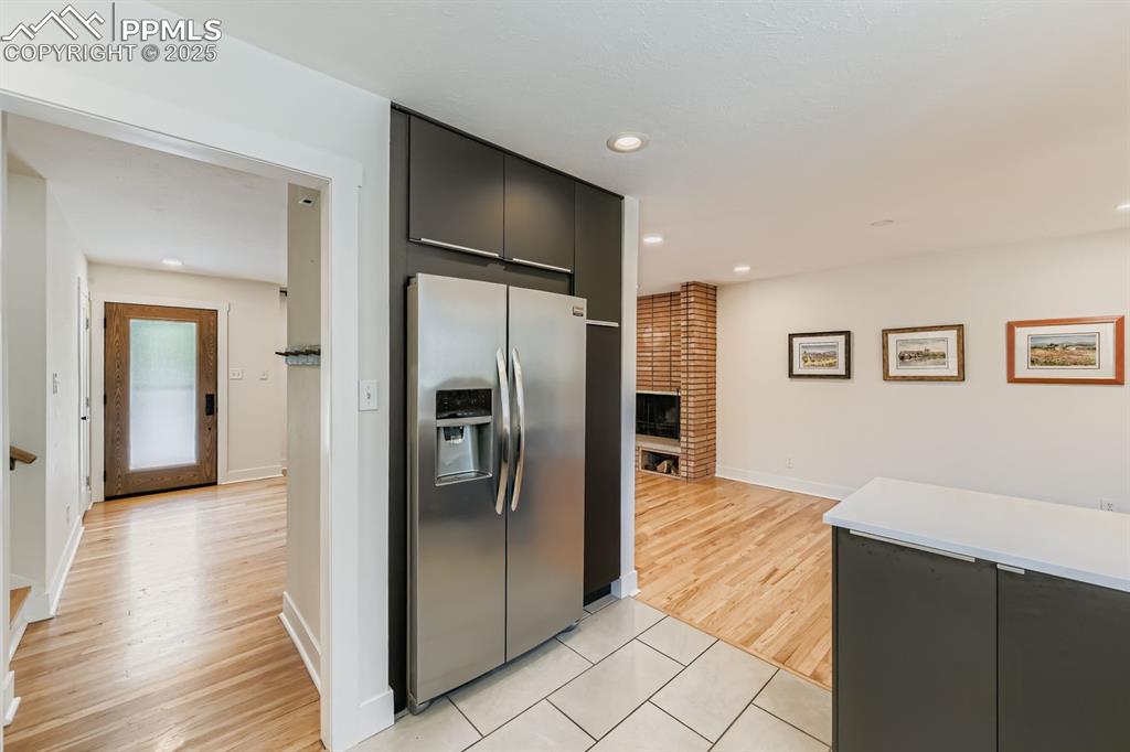 Image 5 of 28: Kitchen featuring stainless steel fridge with ice dispenser, dark cabinets,