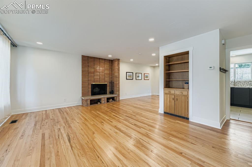 Image 7 of 28: Unfurnished living room with light wood finished floors, recessed lighting,