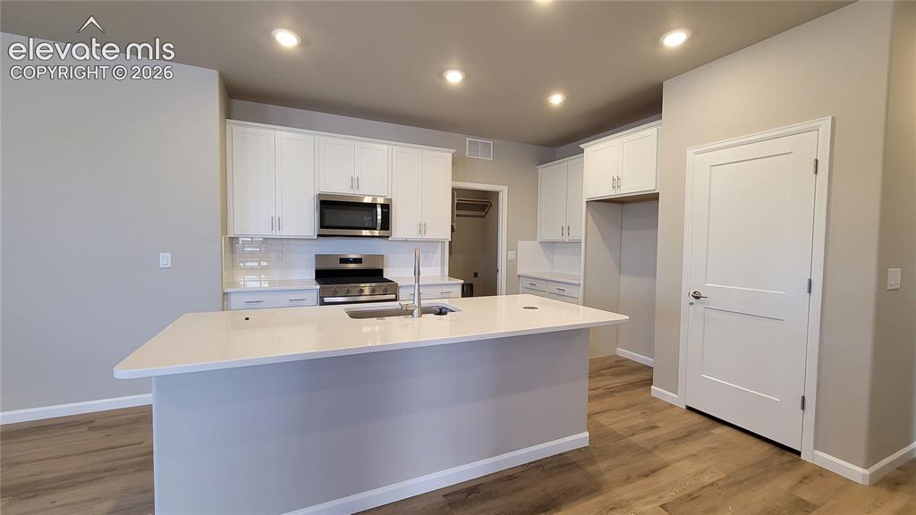 Image 10 of 42: Kitchen with Quartz countertops, pantry, large island providing additional