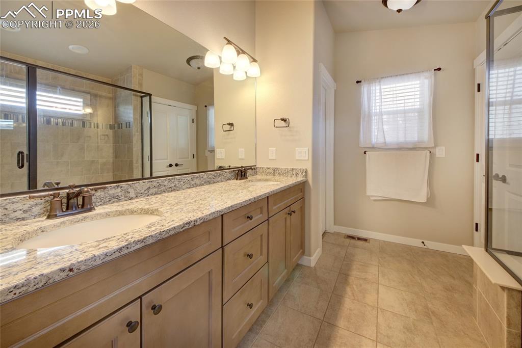 Image 15 of 36: Master bathroom granite tops, ceramic tile floor and double vanity