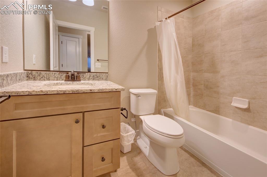 Image 28 of 36: Basement bathroom with granite counters and ceramic tile floors and full