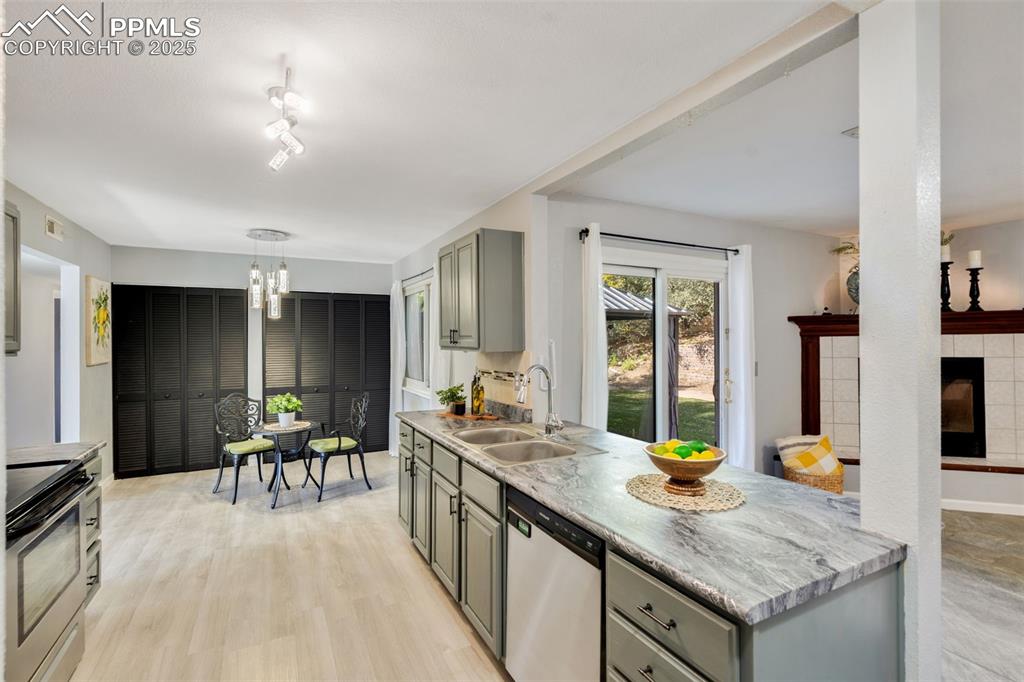 Image 10 of 23: Kitchen with stainless steel appliances, pendant lighting, light wood-type