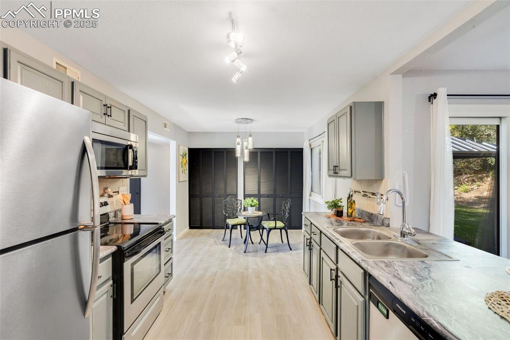 Image 11 of 23: Kitchen featuring gray cabinetry, appliances with stainless steel finishes,