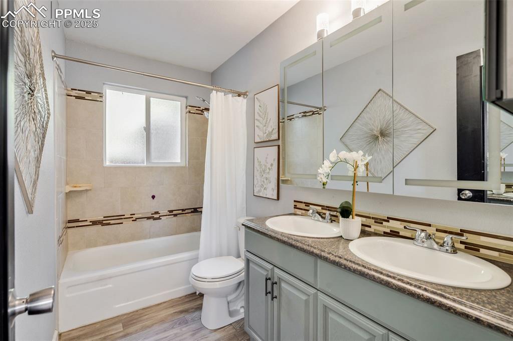 Image 12 of 23: Bathroom featuring shower / bathtub combination with curtain, light wood-st