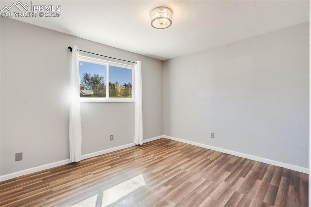 Image 18 of 23: Empty room with baseboards and light wood finished floors