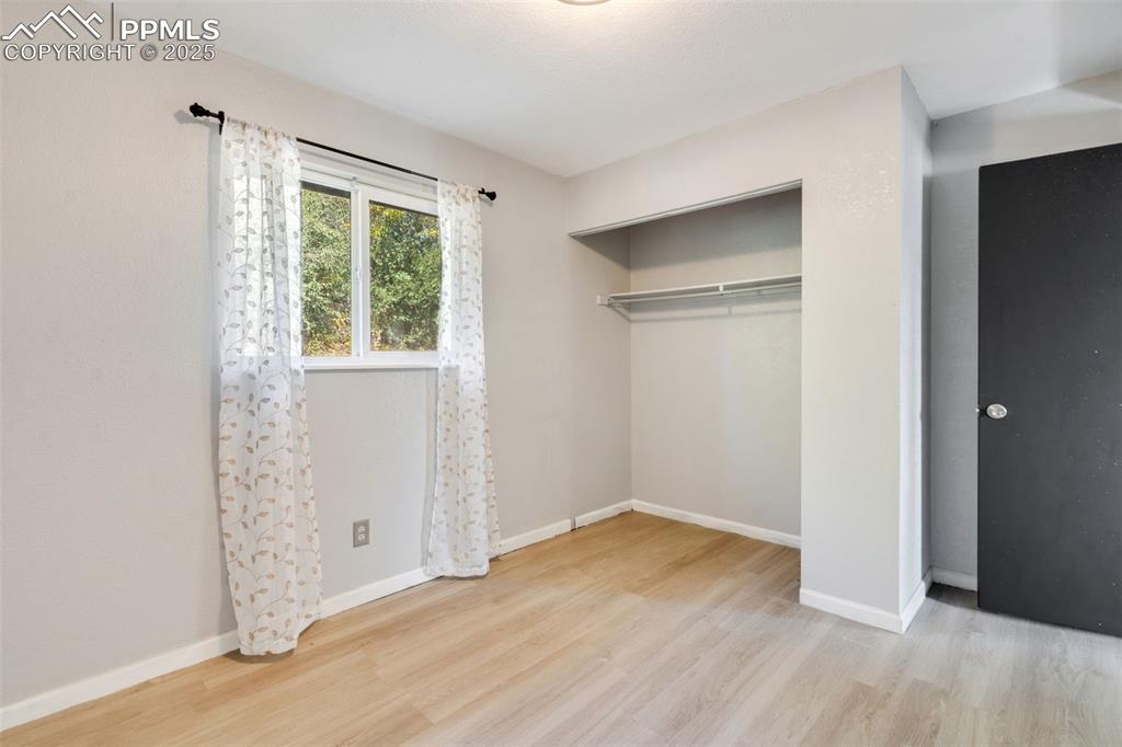 Image 21 of 23: Unfurnished bedroom with light wood finished floors and a closet