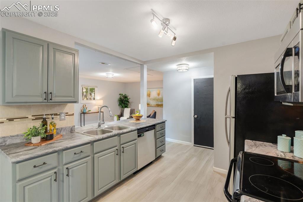 Image 8 of 23: Kitchen featuring appliances with stainless steel finishes, light wood-styl