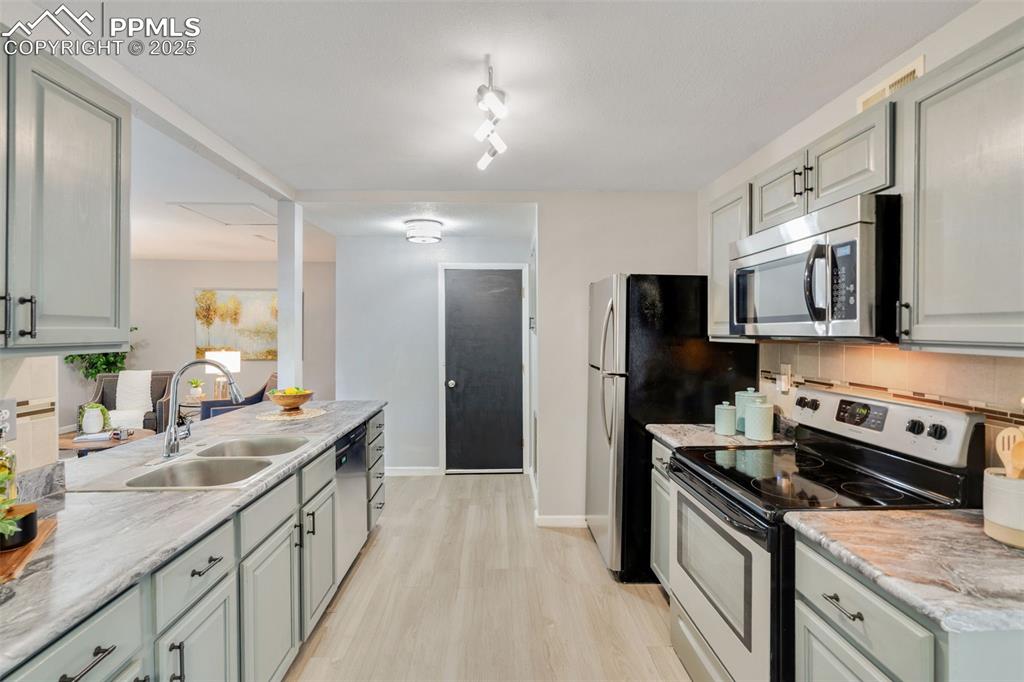 Image 9 of 23: Kitchen featuring stainless steel appliances, tasteful backsplash, light wo