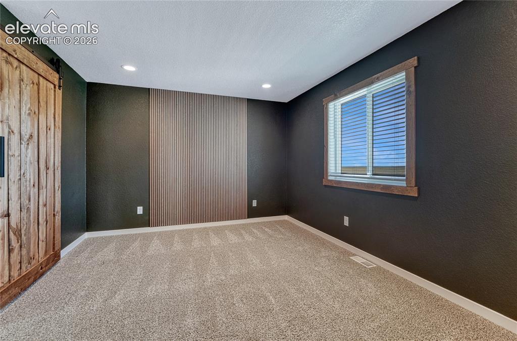 Image 13 of 30: Primary bedroom with feature wall...
