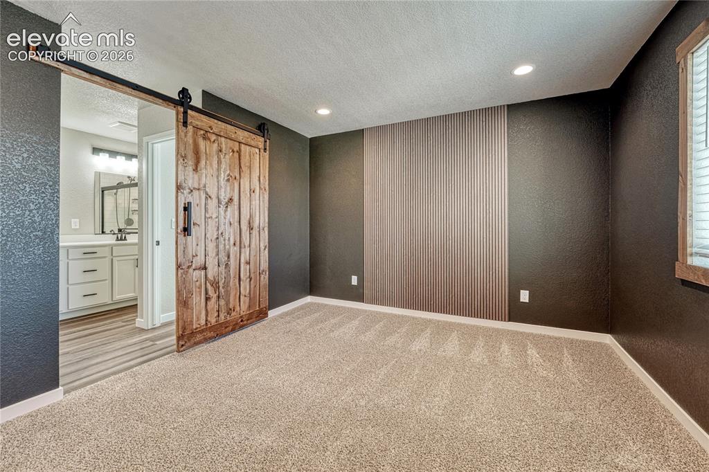 Image 14 of 30: ...and barn door to the adjoining primary bath. 