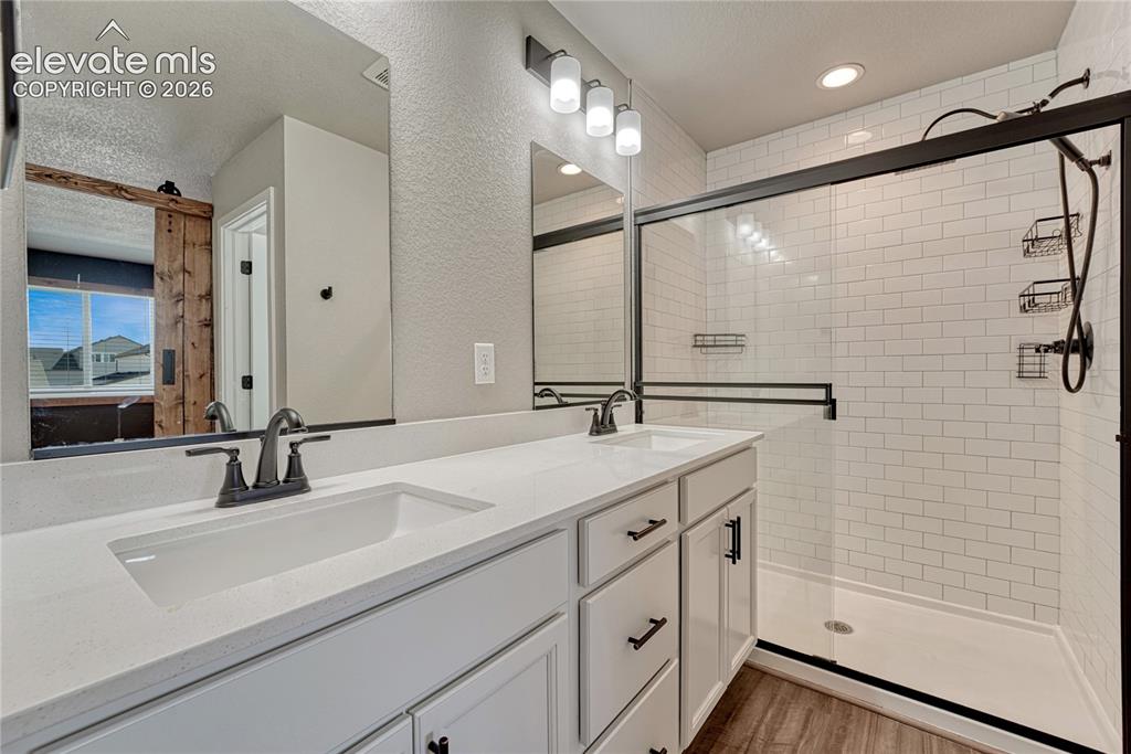 Image 15 of 30: Primary bathroom has quartz countertops, luxury vinyl flooring and subway t