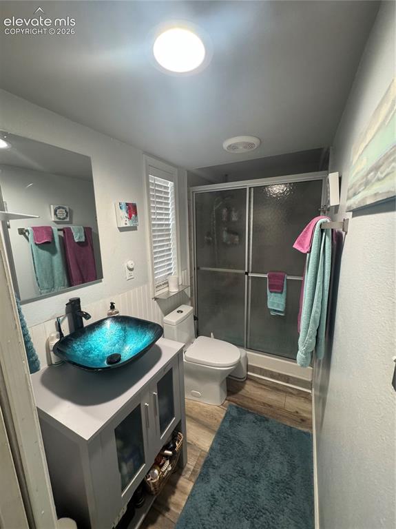 Image 8 of 12: Bathroom featuring a vanity with a vessel sink, matte black faucet, enclose