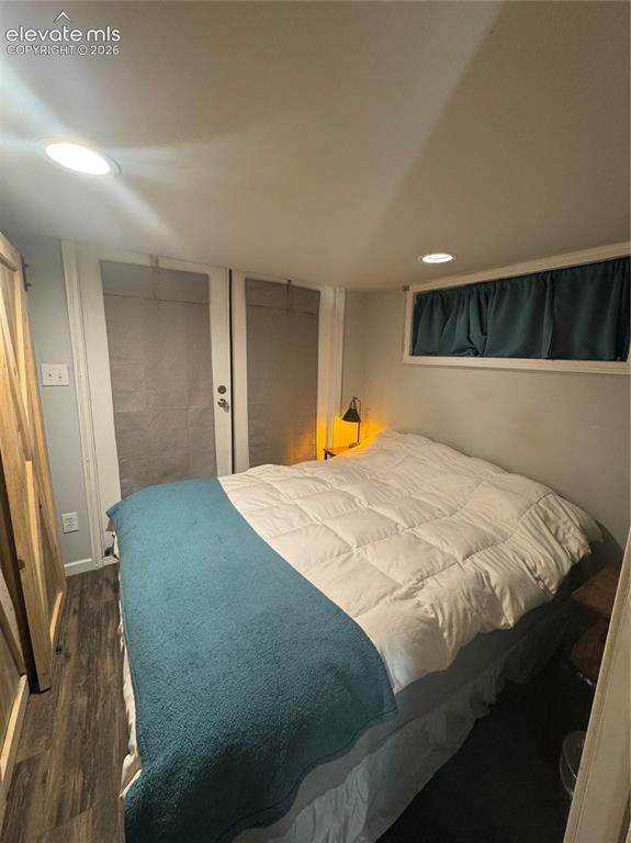 Image 9 of 12: Room featuring recessed lighting, wood-finish flooring, a sliding barn-styl