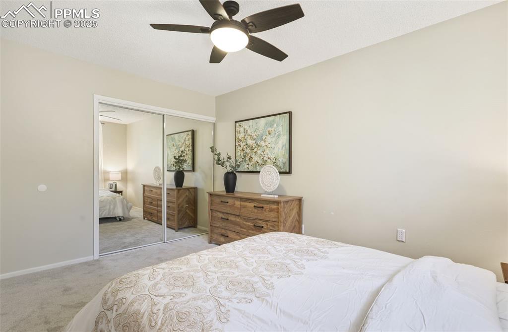 Image 11 of 34: Carpeted bedroom with a ceiling fan, a closet, and a textured ceiling