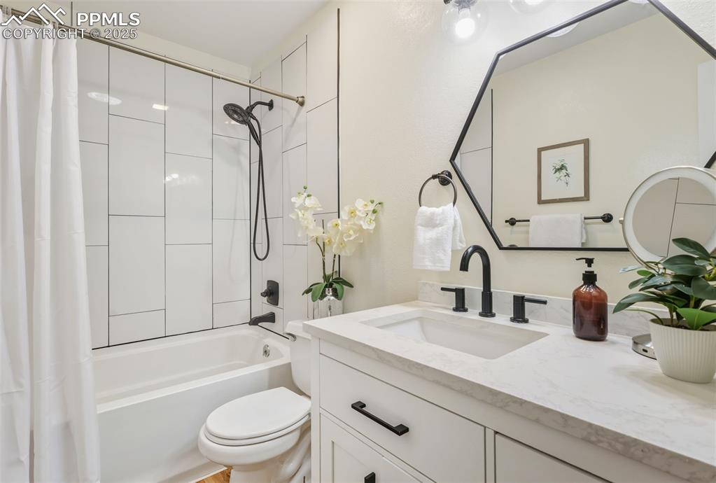 Image 12 of 34: Updated Full bath featuring shower / bath combination with curtain and vani