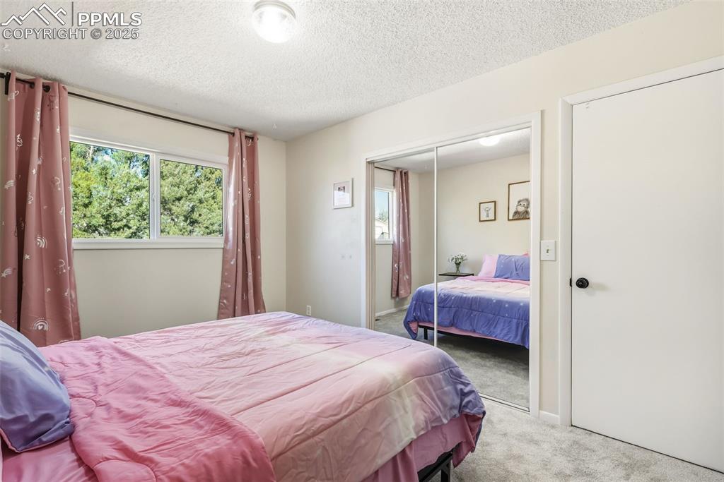 Image 14 of 34: Carpeted bedroom with a textured ceiling and a closet