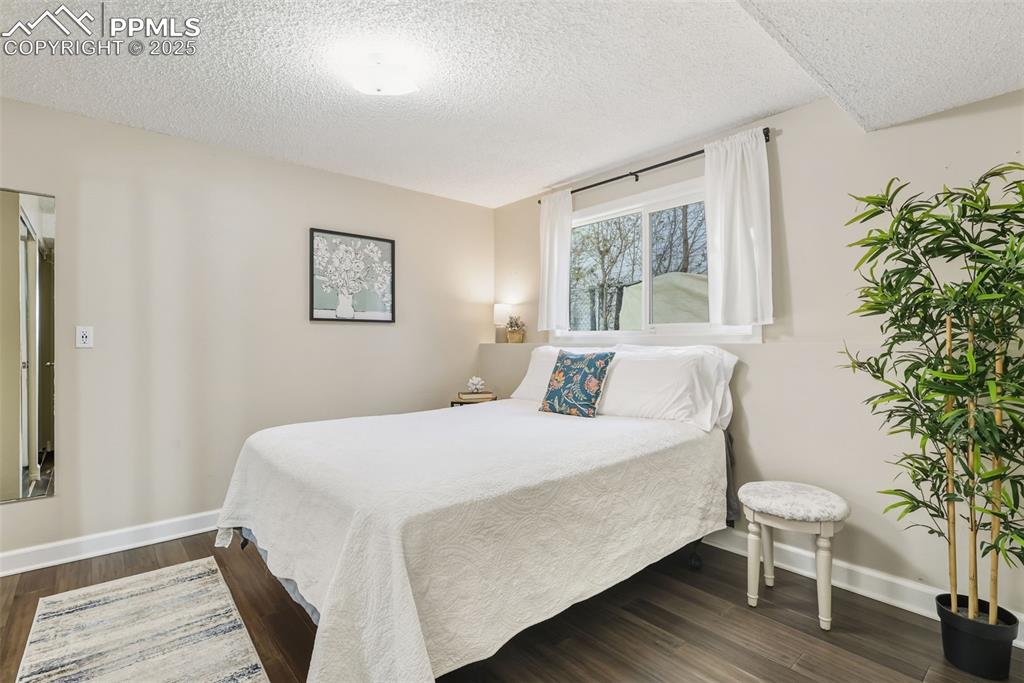 Image 19 of 34: Bedroom with a textured ceiling and dark wood finished floors, and ensuite 