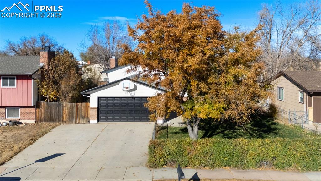 Image 2 of 34: View of front of house featuring brick siding, a garage, and landscaped fro