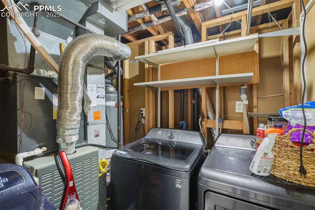 Image 23 of 34: Washroom featuring heating unit and washing machine and clothes dryer
