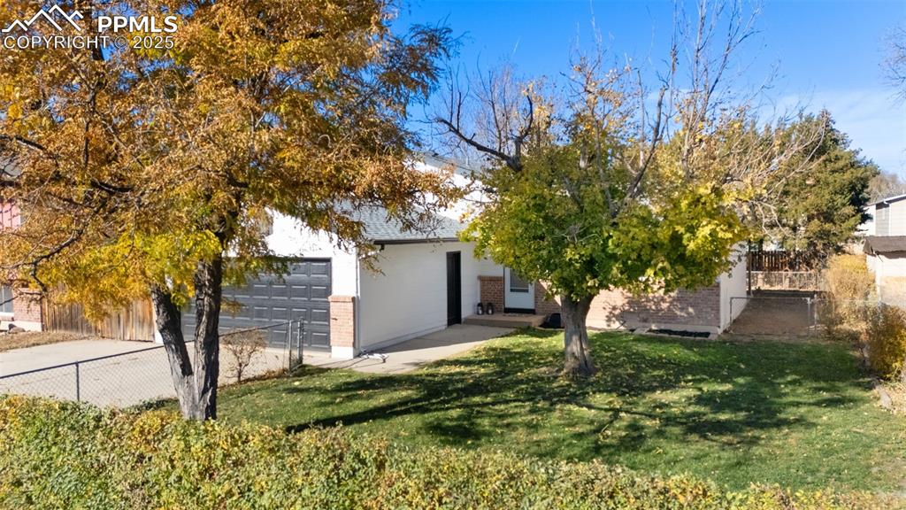 Image 26 of 34: Obstructed view of property with brick siding, a garage, and driveway